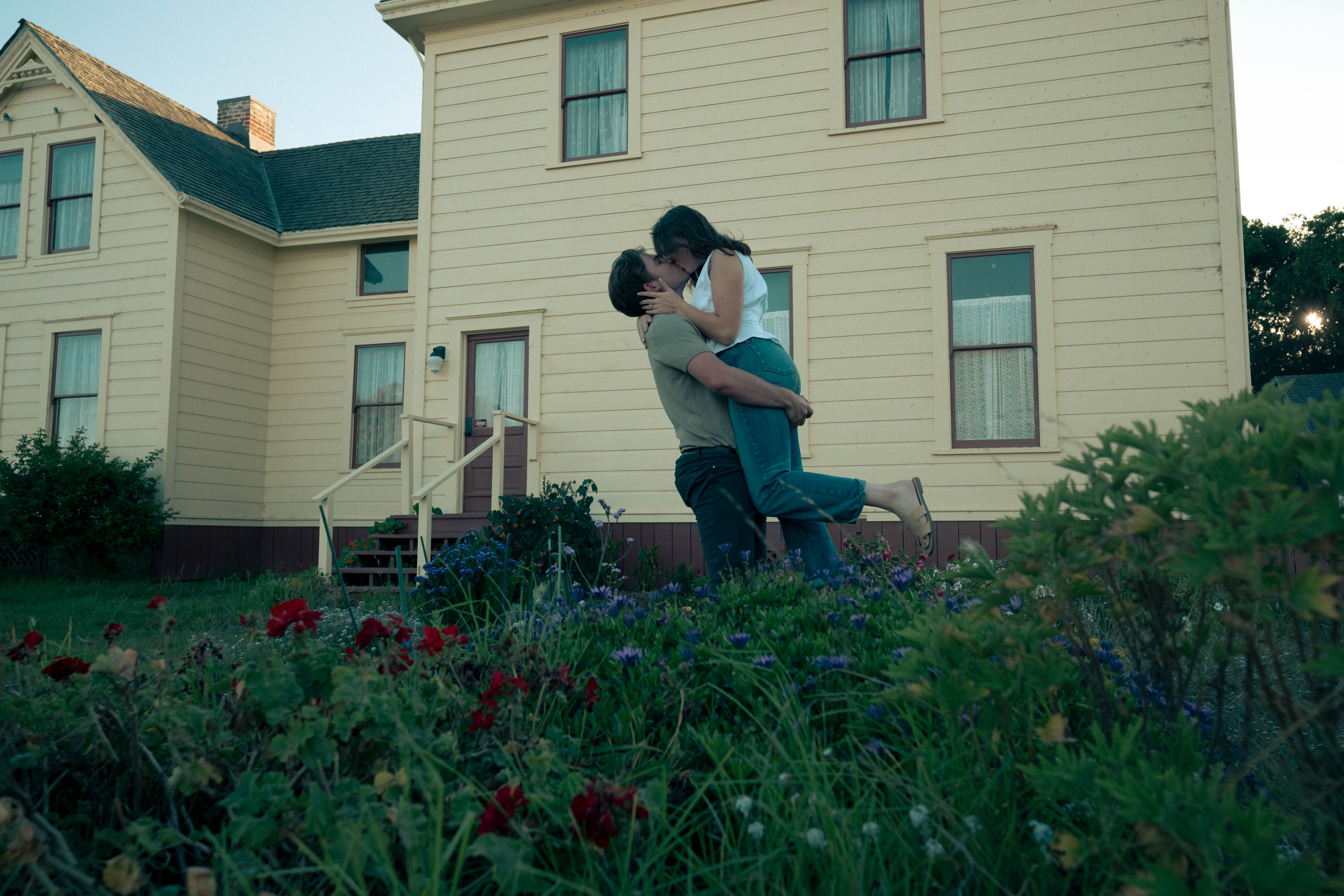 Couple in joyful embrace in front of Victorian house - documentary wedding photography by Jesse Fox