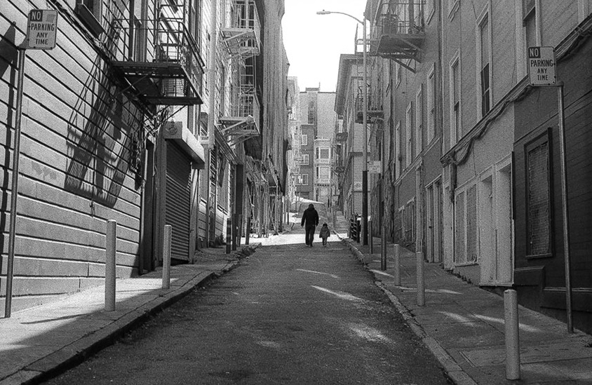 Black and white urban alley with fire escapes